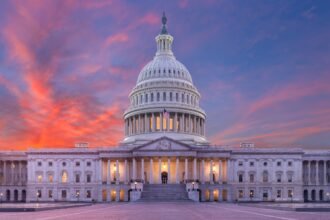 United States Capitol building viewed across a wide landscape at dusk, evoking the federal-state fight over AI regulation