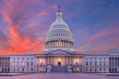 United States Capitol building viewed across a wide landscape at dusk, evoking the federal-state fight over AI regulation