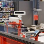 A shopping cart icon connected to AI agent nodes representing automated agentic checkout across multiple platforms